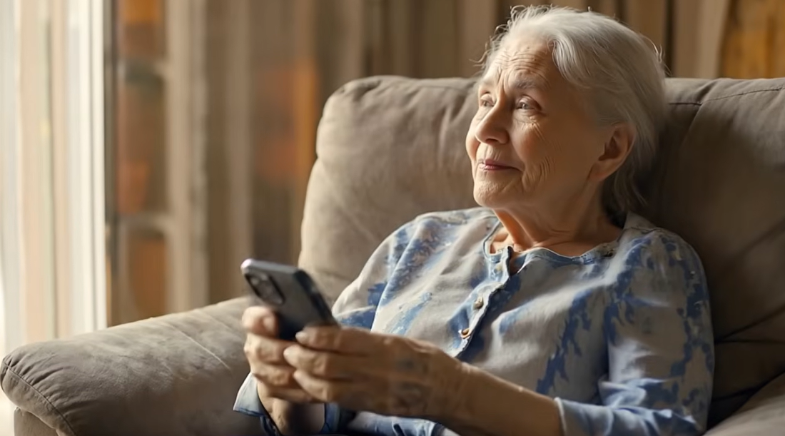 Elderly woman holding a phone, ready to call her loved one